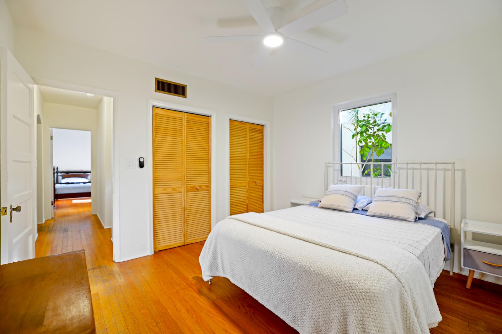 Main bedroom view with warm natural light and hardwood floors