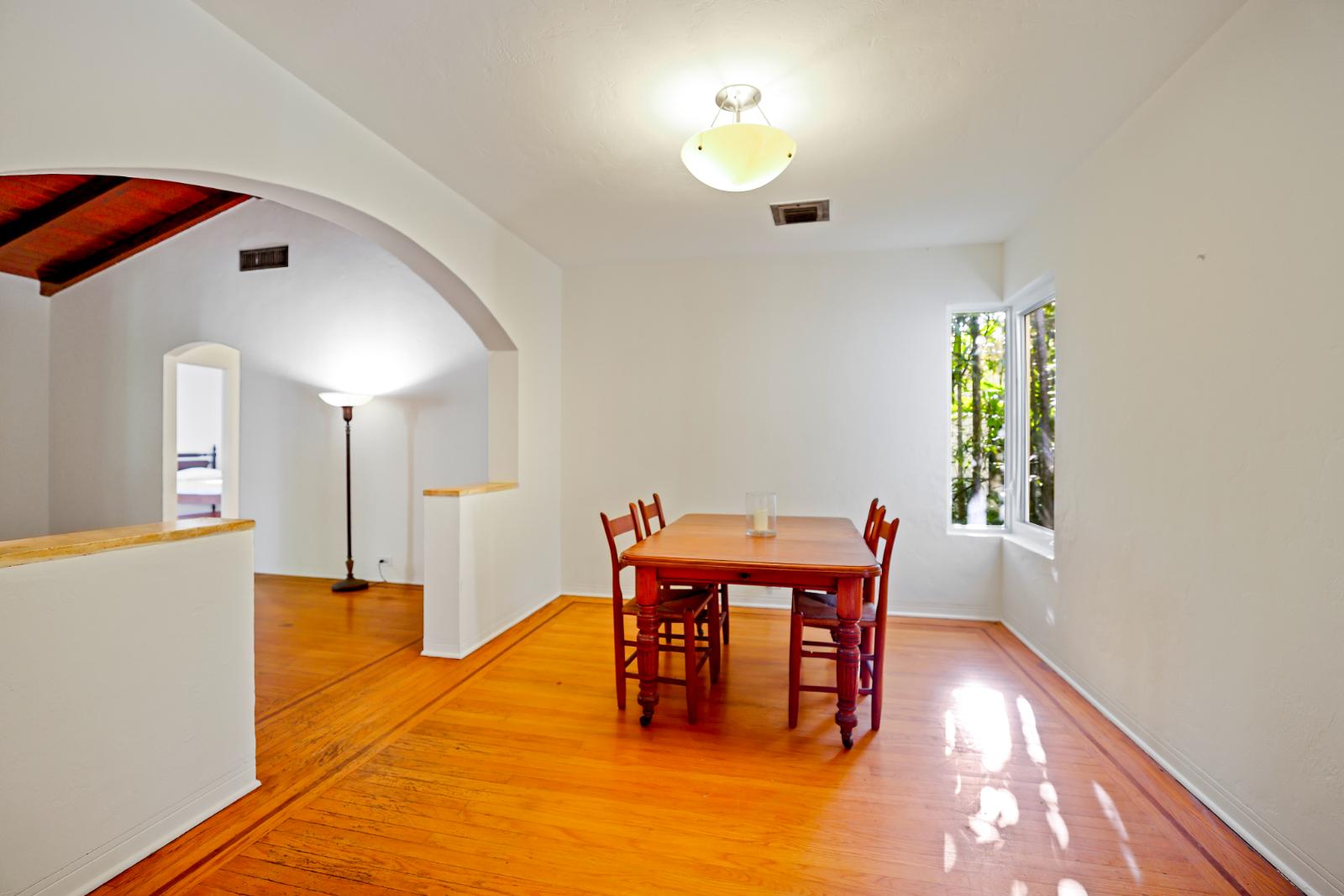 Dining room with warm flooring and adjacent living connection
