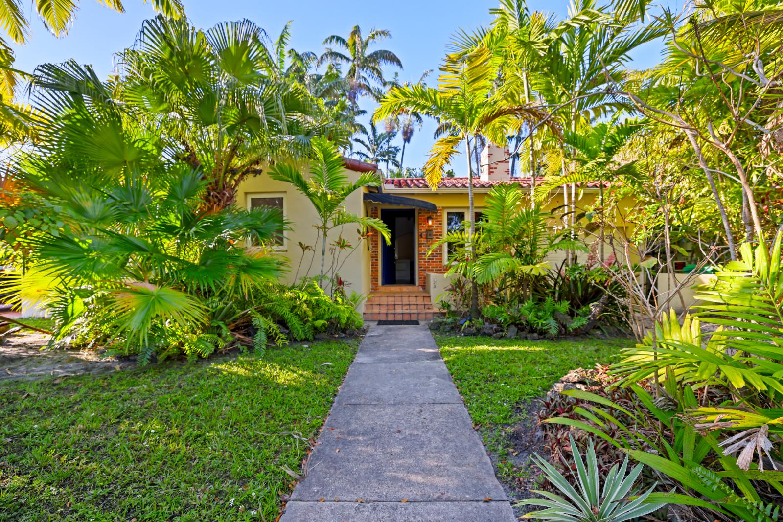 Front walkway view of 720 NE 75th St in Belle Meade with tropical landscaping and entry path