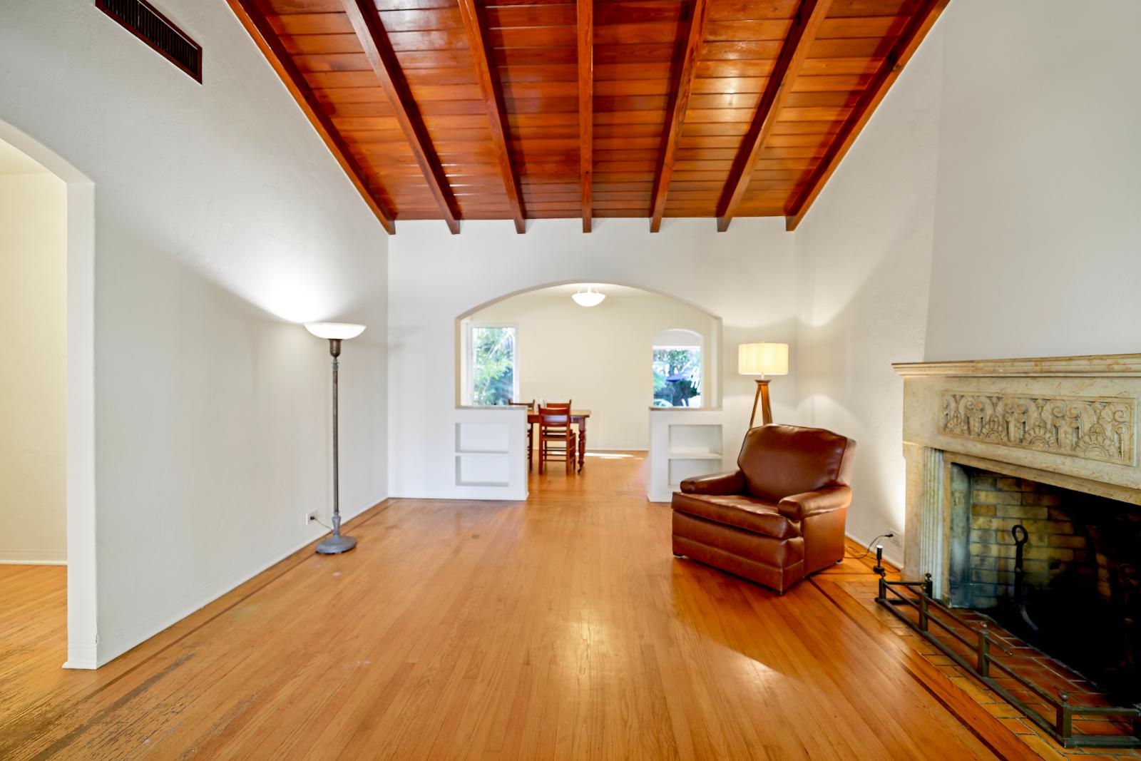 Living room with hardwood floors, bright natural light, and warm architectural character