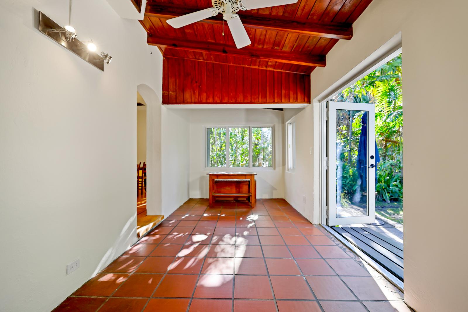 Sunroom with terracotta floor and exposed wood ceiling